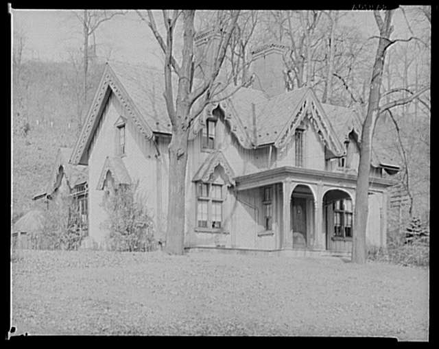 Victorian home with ornate woodwork, steep roof, and wrap-around porch