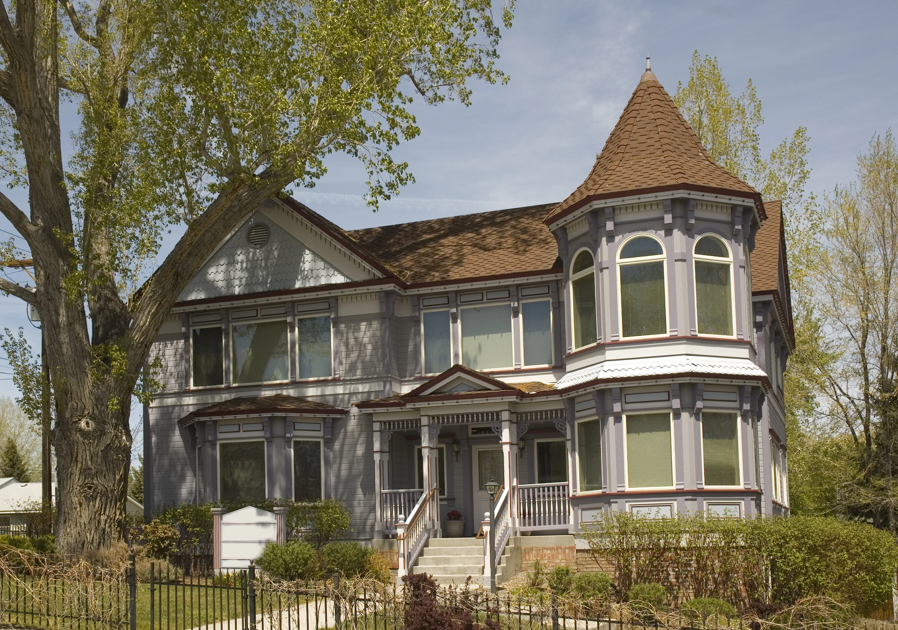 Victorian-style home with turret, bay windows, and wrap-around porch