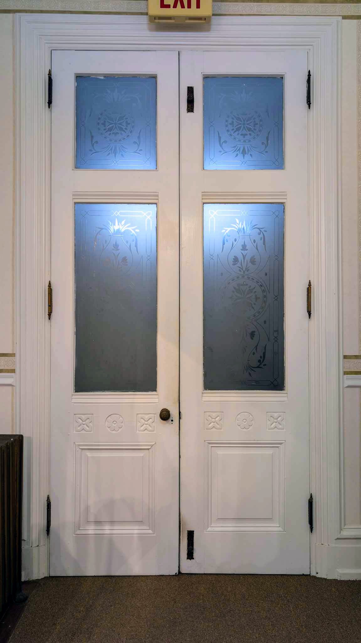 Pair of Victorian doors with etched frosted-glass panels and carved lower panels.