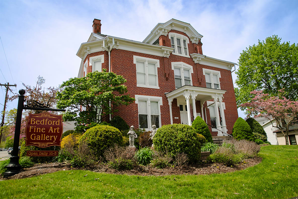 The Barclay House, home of Bedford Fine Art Gallery, a red-brick Italianate mansion behind its garden and sign.