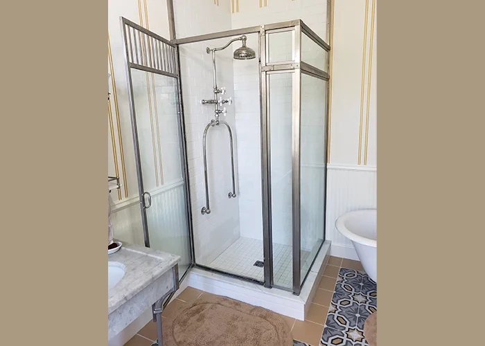 Restored Victorian bathroom showcasing a glass shower and freestanding tub