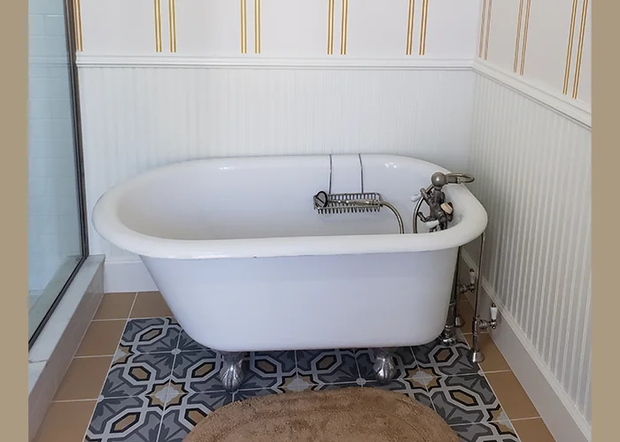 Victorian bathroom with a clawfoot tub and decorative tile flooring